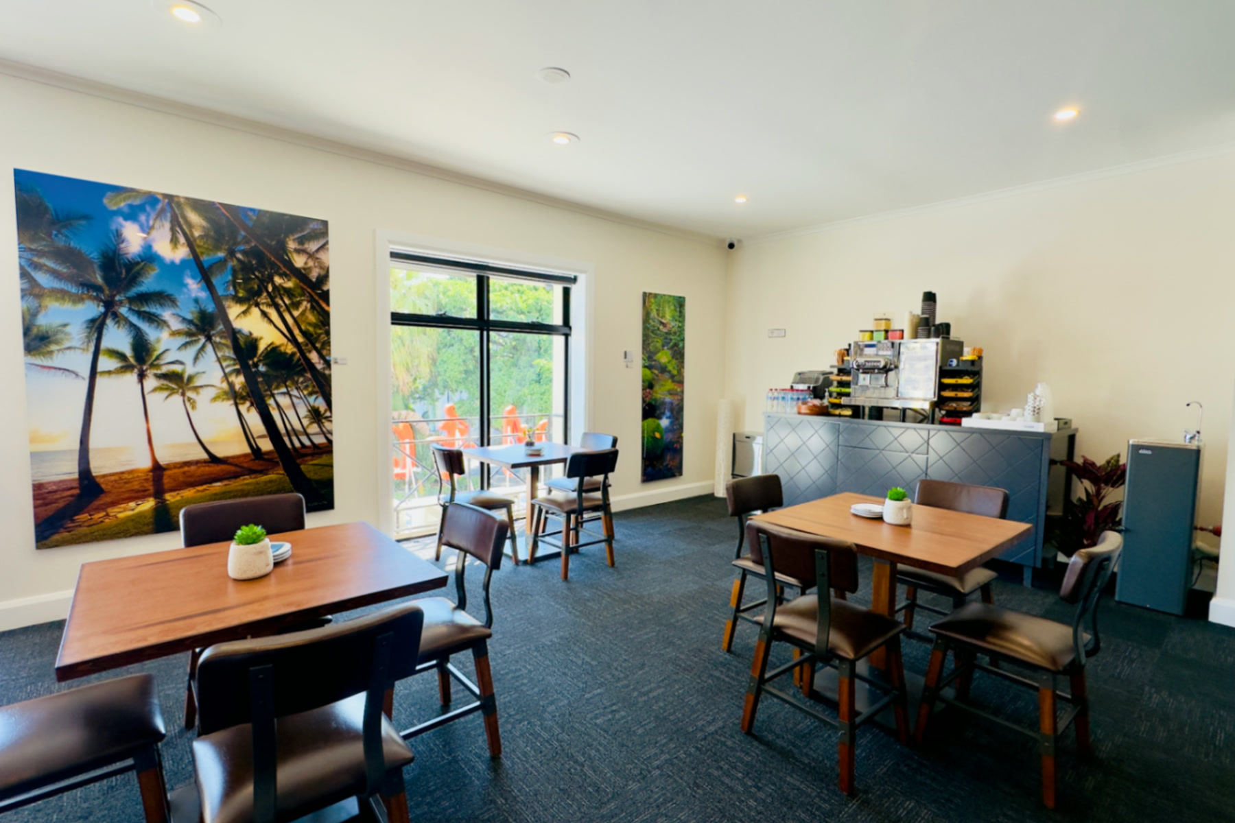 Guest lounge dining area with tropical artwork and window seating